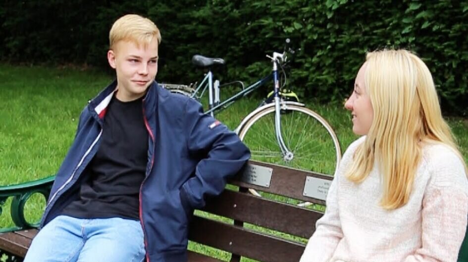Two young people chatting on a bench
