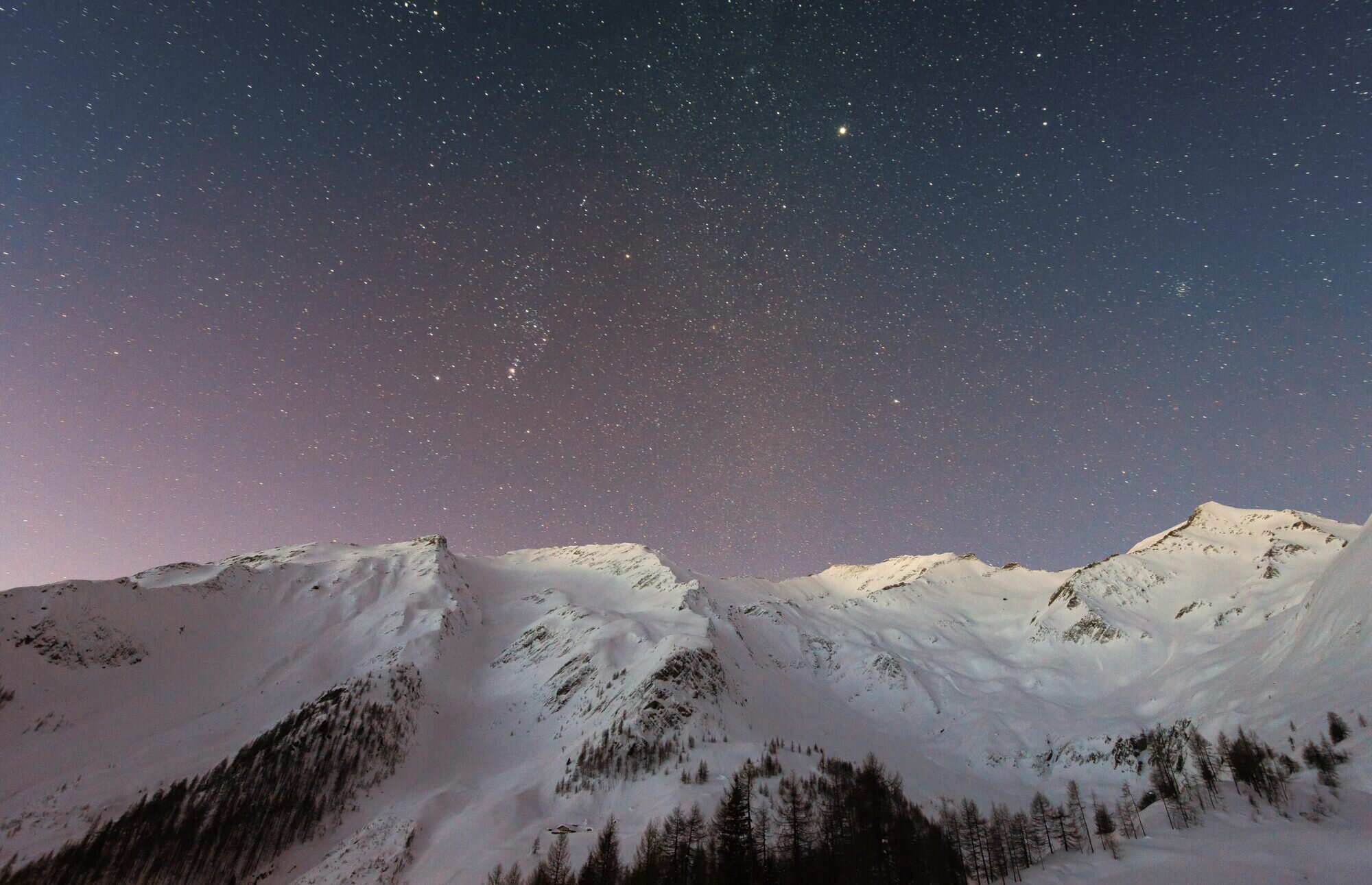 night sky above snowy mountains